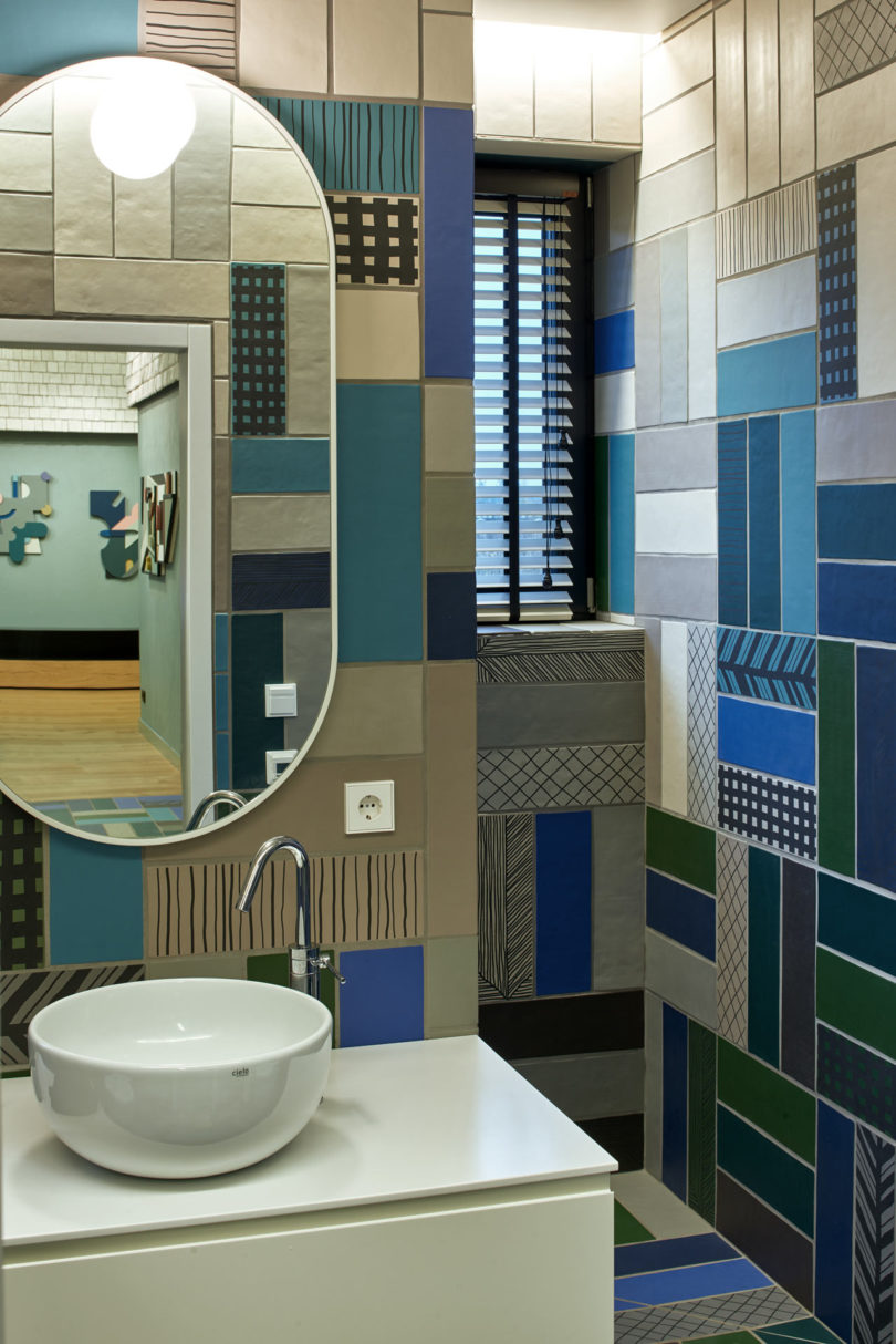 The bathroom is clad with colorful mosaic tiles that remind of the repeated patterns throught the house
