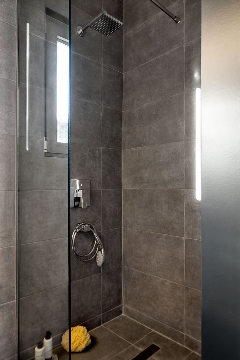 The small bathroom features a concrete clad shower