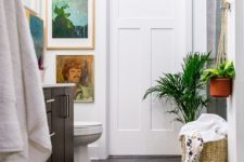 08 a boho rug, baskets with towels, potted plants and some artworks make this bathroom boho chic