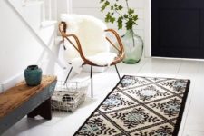 08 a rug, a wood and metal bench, a rattan chair with faux fur, a metal basket