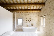 08 a rural Provence bedroom with much stone and wood and a bathtub by the window to enjoy the views