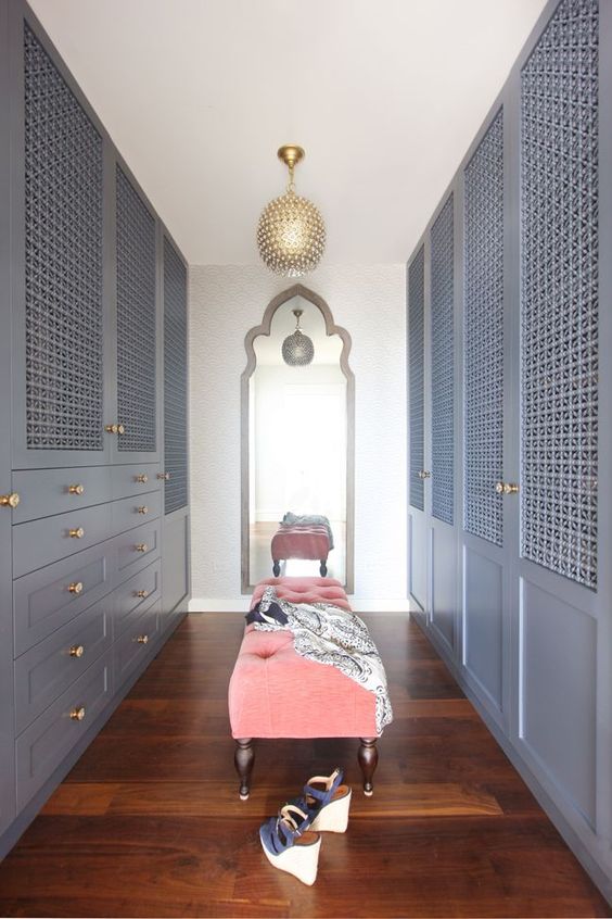 a slate grey closet done with wood lattice doors looks very elegant with a vintage feel