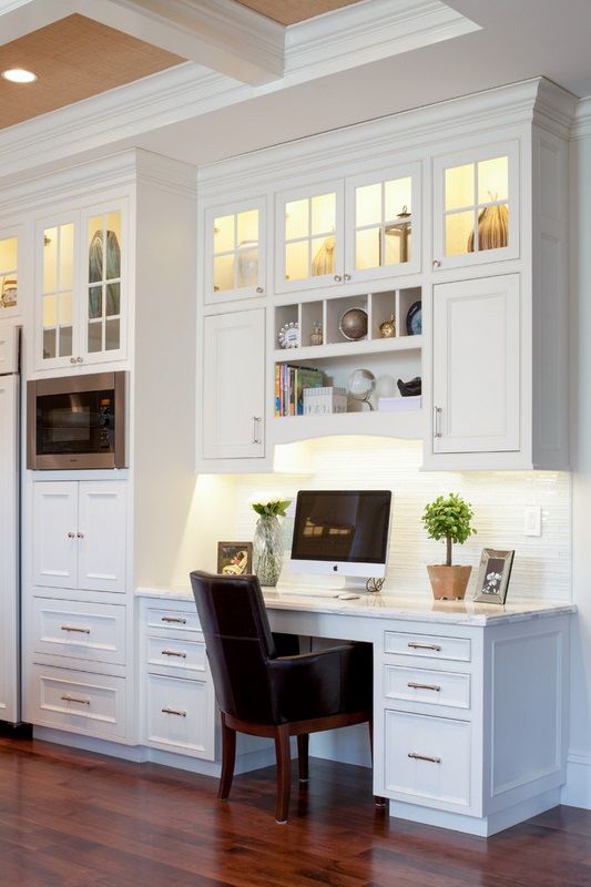 a white farmhouse kitchen with a seamless office nook with built-in lights and a large comfy desk