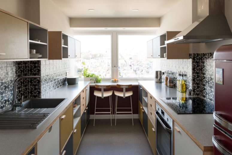 The kitchen is done in grey, yellow, white and patterned tile backsplashes, the breakfast space is on the windowsill