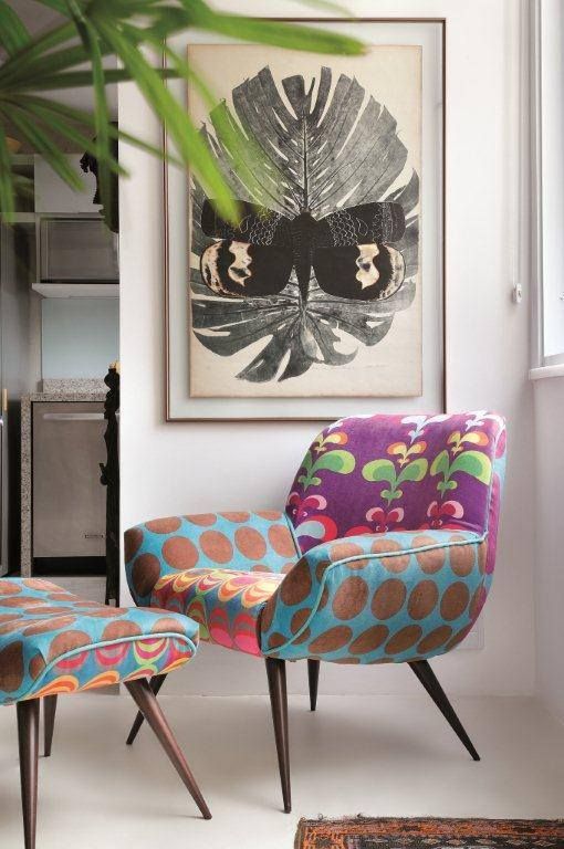 A colorful mid century modern chair with different armrests, a seat and a back plus a matching footrest