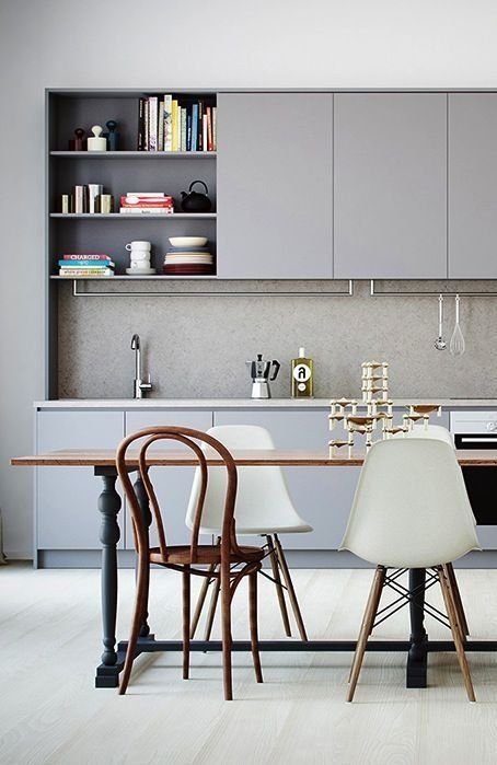 a monochrome grey kitchen is perfectly completed with a raw concrete backsplash that makes it cooler