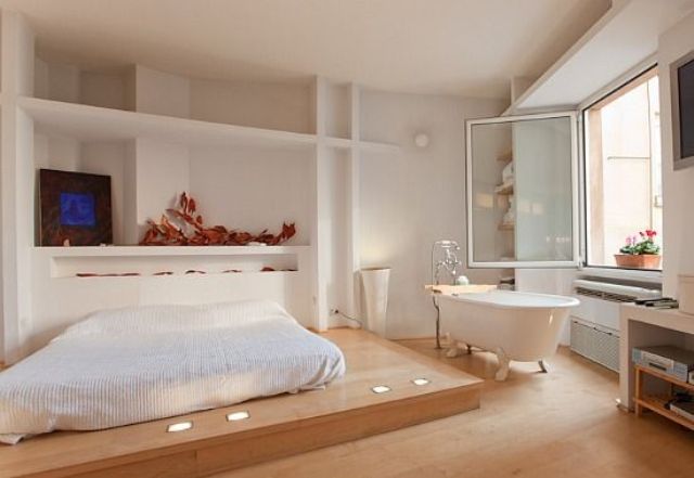 an airy Japandi bedroom with a free-standing bathtub by the window to enjoy the views