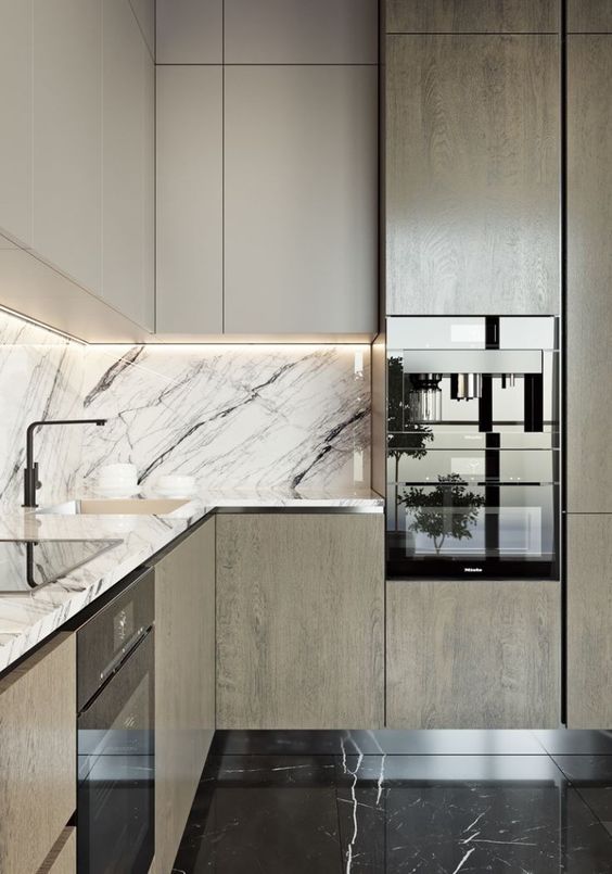 An elegant modern two toned kitchen with a black and white marble backsplash and countertop for a refined feel