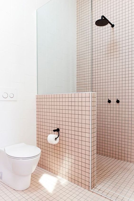 light pink tiles are highlighted with black grout and contrasting white touches