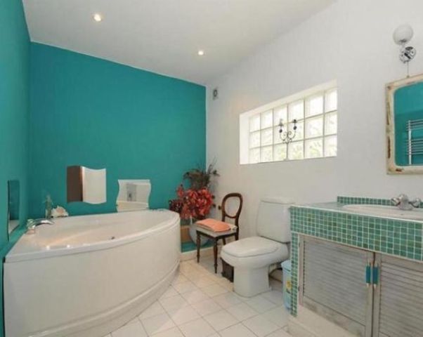 two walls painted turquoise make the bathroom brighter and cooler and create a mood