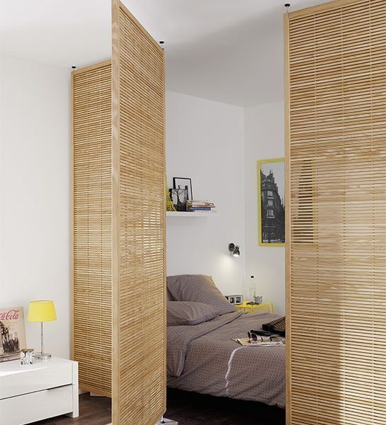wood lattice doors gently separate the sleeping zone from the rest of the open layout letting light in