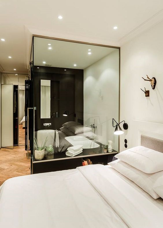 a black and white contemporary bedroom with a bathtub in a glass cube to integrate it into the decor