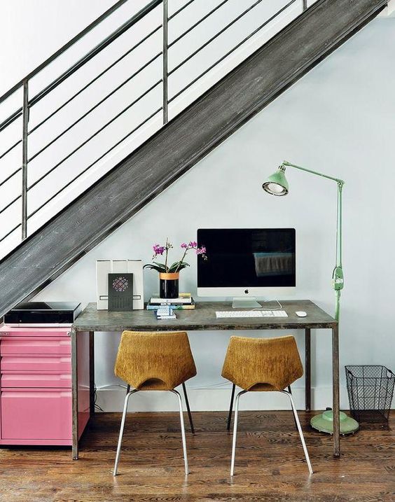a wood and metal staircase lets light in and a green floor lamp adds more light