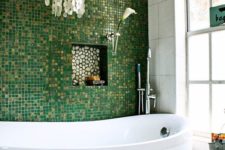 11 glossy green and gold glitter little tiles for an accent wall, mother of pearl chandelier create a glam space