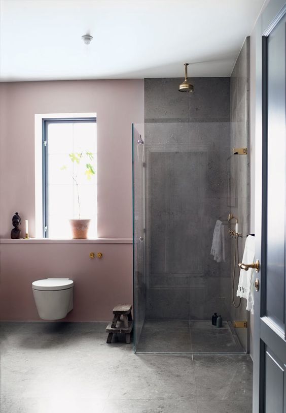 the contrast between pink walls and grey concrete is striking and the space doesn't look too glam and girlish