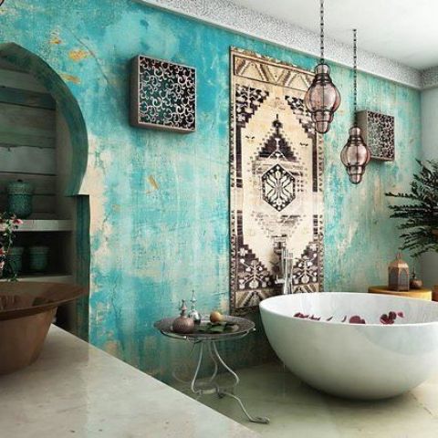 a Moroccan styled bathroom with a watercolor turquoise wall, lanterns and other details