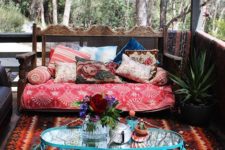 12 a gypsy-styled porch with a bright printed rug, a colorful bench and a blue forged side table