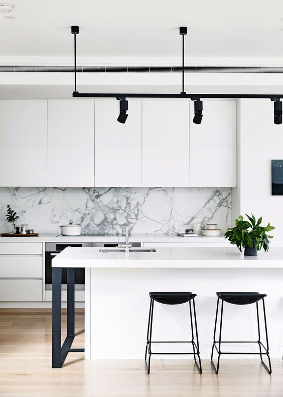 a monochromatic space in black and white with a white marble backsplash and black lights for a deeper look