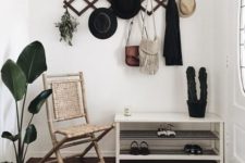 a simple shoe shelf, a woven chair, a geometric hanger on the wall and a geo rug