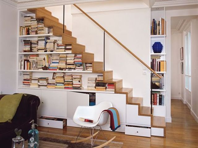 a modern staircase that features cabinets for storage and open bookshelves