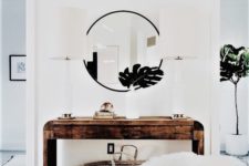 13 a rough wood console table, a round mirror, a faux fur stool and tropical leaves