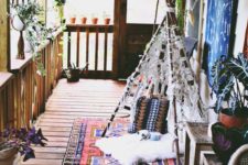 14 a boho porch with a printed rug, a teepee with macrame, lanterns, potted greenery plus rattan stools