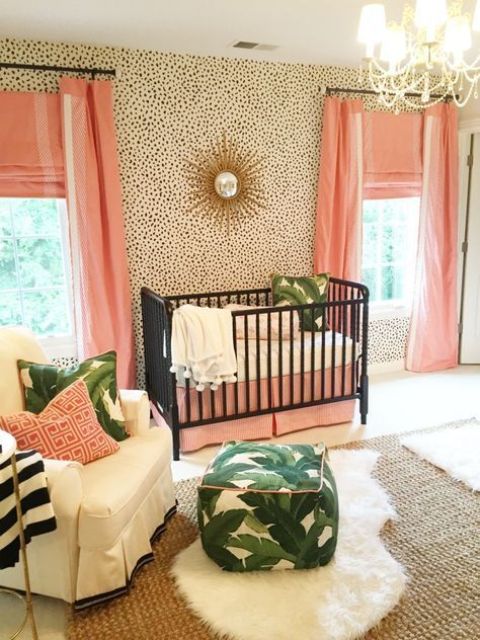 a glam tropical nursery with dalmatin print walls, pink textiles, black cribs and leaf print accessories