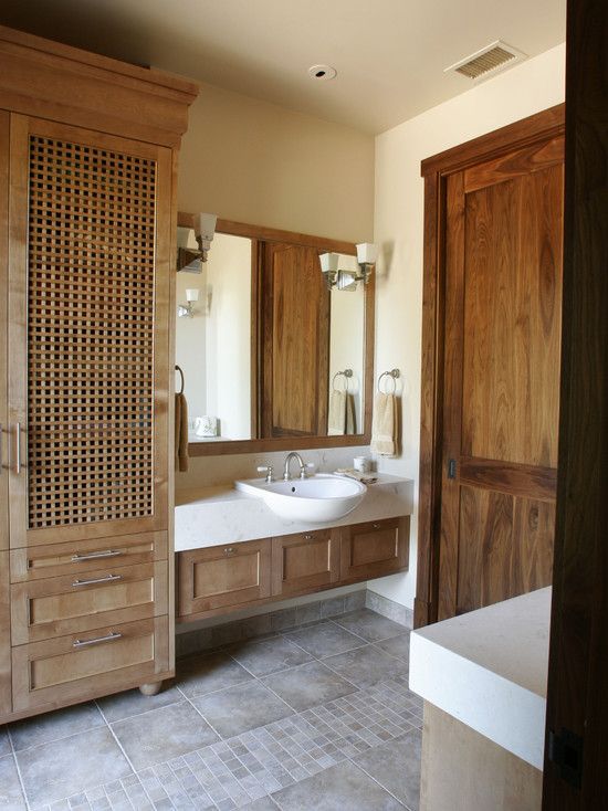 a large wardrobe with wood lettice doors brings a relaxed and vacation feel to the bathroom