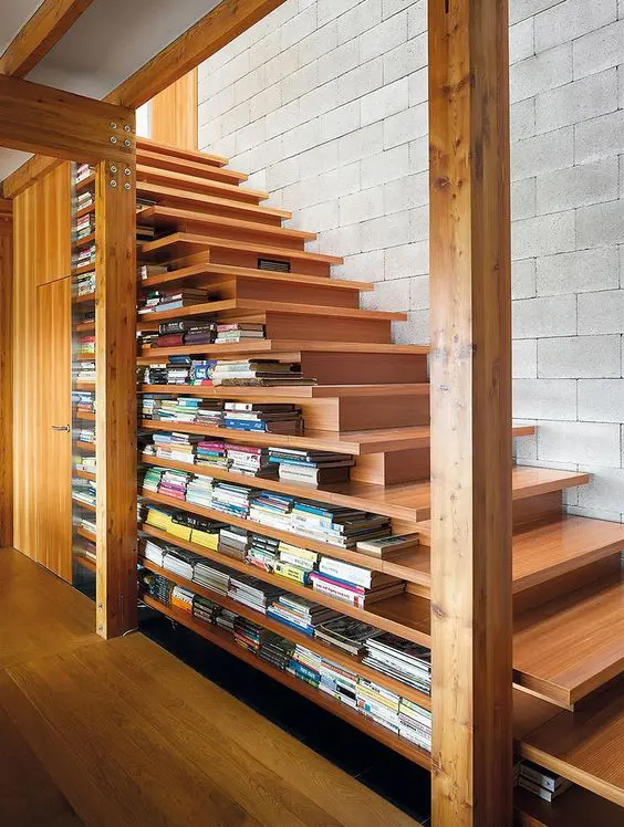 A modern take on a traditional staircase with two sided steps and lots of book stored there