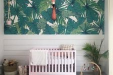 15 a simple tropical space with a palm leaf statement wall, a pink crib, a faux flamingo head on the wall