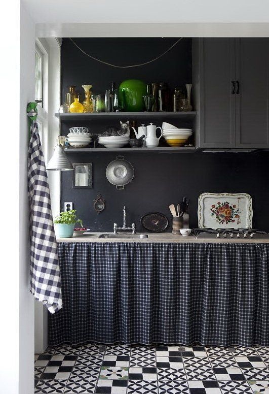 a vintage grey kitchen with a chalkboard backsplash that brings drama to the space