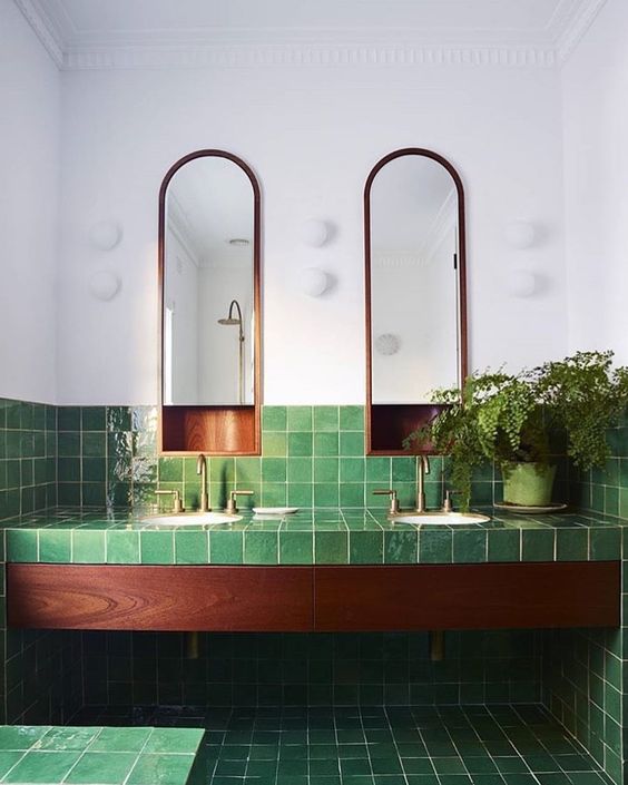 glossy green tiles with a texture and rich wood plus potted greenery for a luxurious and relaxing space