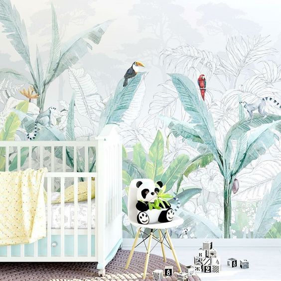 a fun tropical nursery with a creative watercolor tropical statement wall, colorful bedding and a panda toy