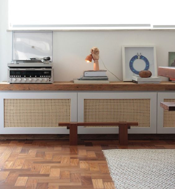 a long storage unit with wood lettice doors and a wooden countertop for a mid-century modern feel