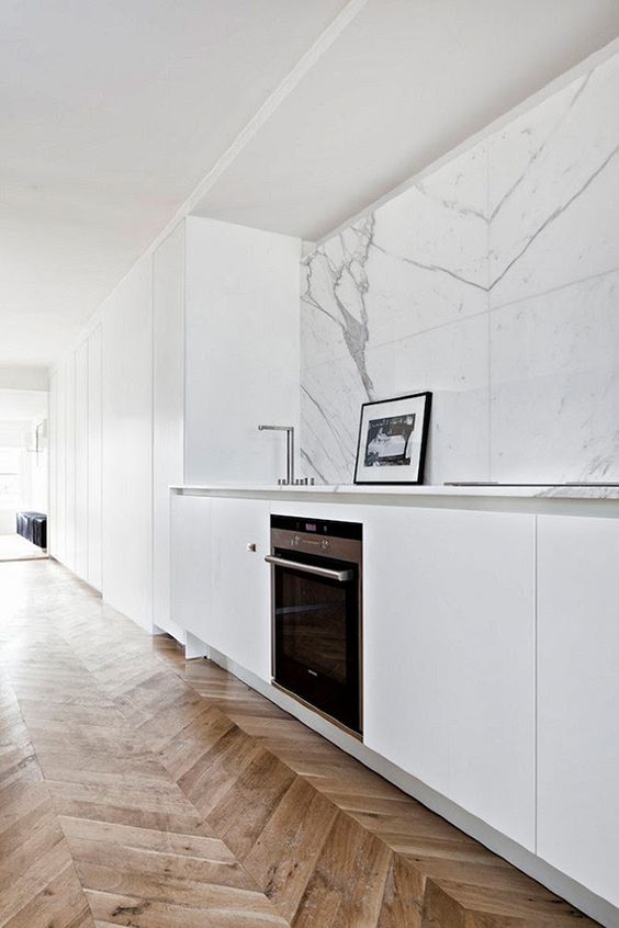 a minimalist white kitchen with a white marble tile backsplash and touches of grey for a chic look