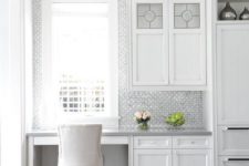 16 a serene white kitchen with a built-in office nook with printed wallpaper to highlight it and a comfy upholstered chair