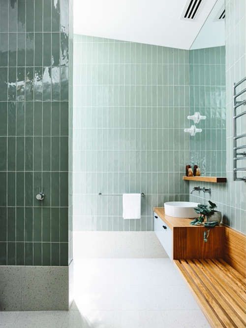 glossy pale green tiles and warm-colored wood create a very natural space with a calming effect