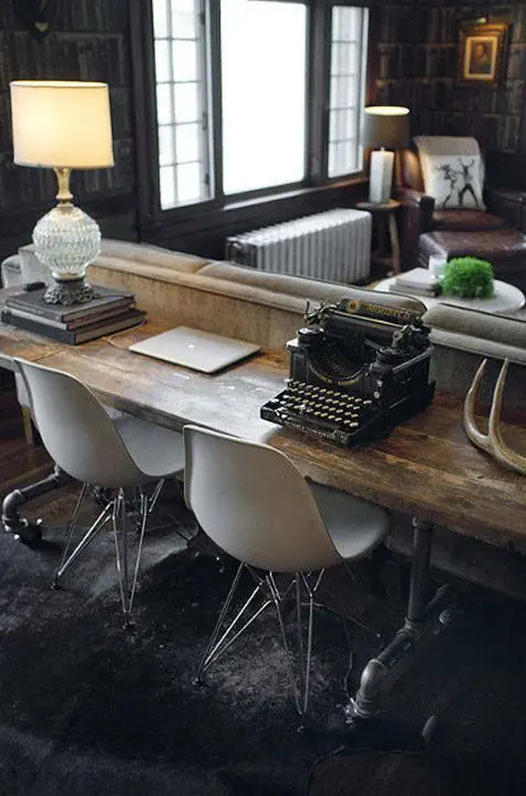 a vintage rustic desk with modern chairs placed behind the couch matches the space but accents it with the chair design