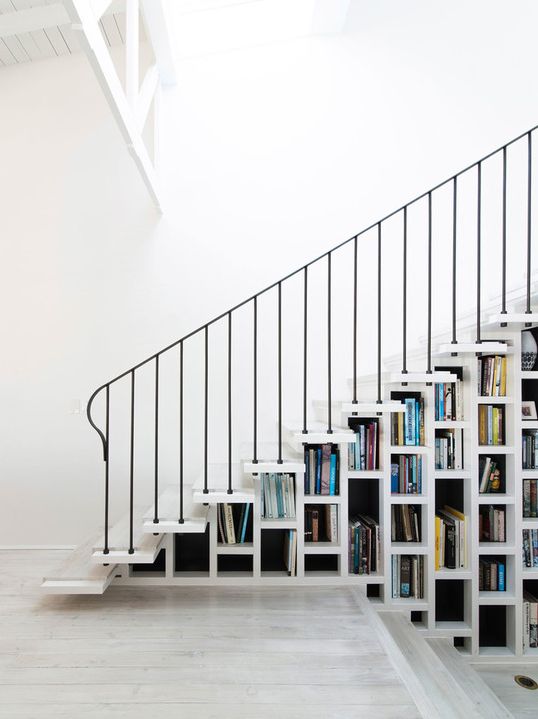 a white staircase that acts as a bookcase is all you need to save a lot of space in your home