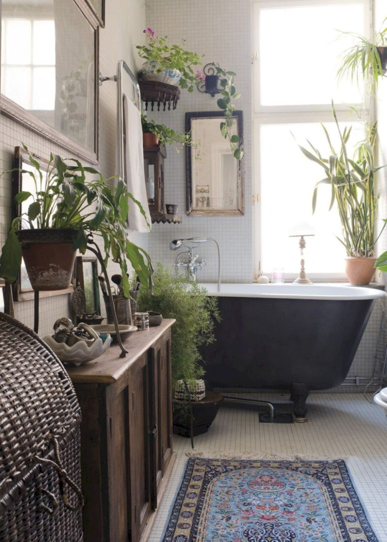 a boho bathroom as a greenery oasis with white tiles, wooden furniture and a woven chest for towels