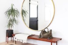 18 a boho rug, a wooden bench, an oversized round mirror, a potted plant