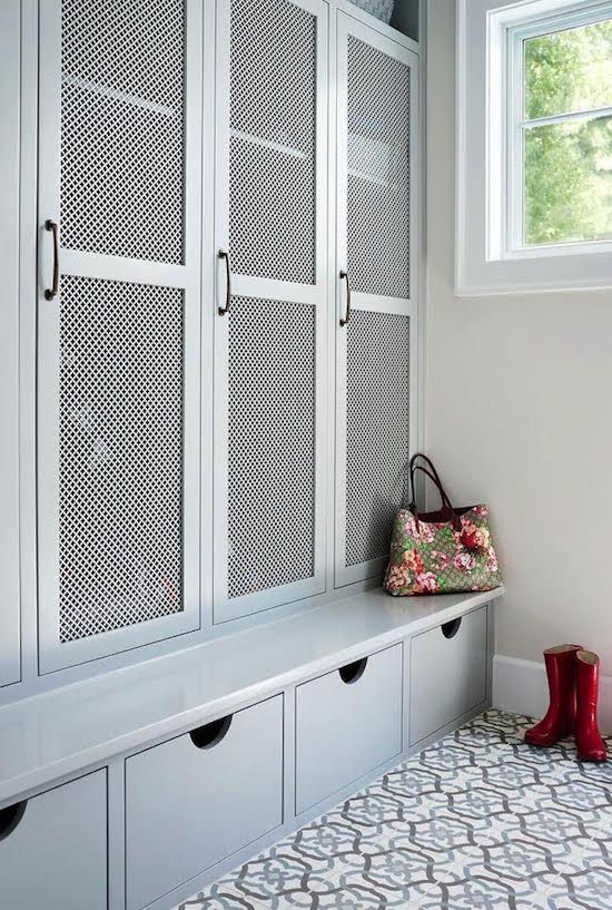a traditional mudroom with a large closet unit with wood lattic doors to let the air in