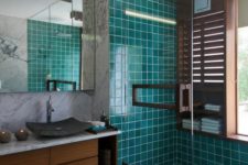 18 turquoise and teal tiles covering the floor and the shower contrast the rich shades of wood and create a mood