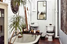 19 a boho bathroom with wooden floors, antique furniture, a free-standing bathtub and potted greenery