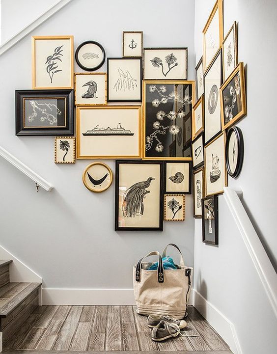 an awkward nook on the stairs is taken by a gorgeous gallery wall in black and gold