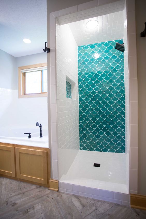 turquoise fish scale tiles are complemented with white subway ones to make the shower bolder