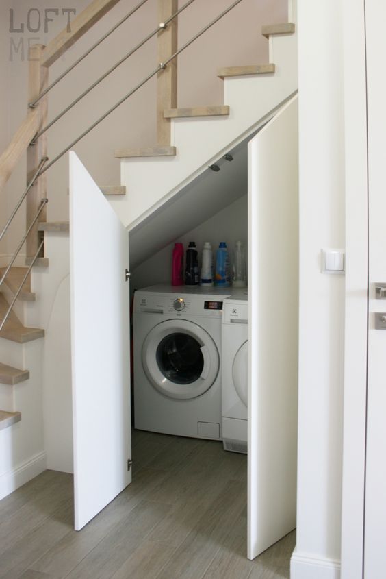 a small laundry with a washing machine and a dryer and with doors