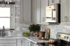 20 a traditional grey kitchen with glam touches like a crystal chandelier and a grey marble tile backsplash