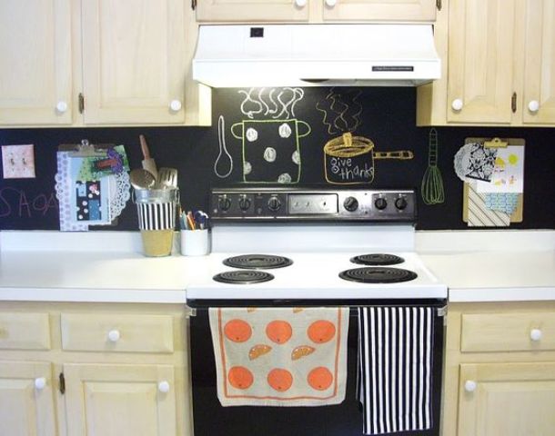 an ivory kitchen with white countertops and a chalkboard backsplash for a contrasting look