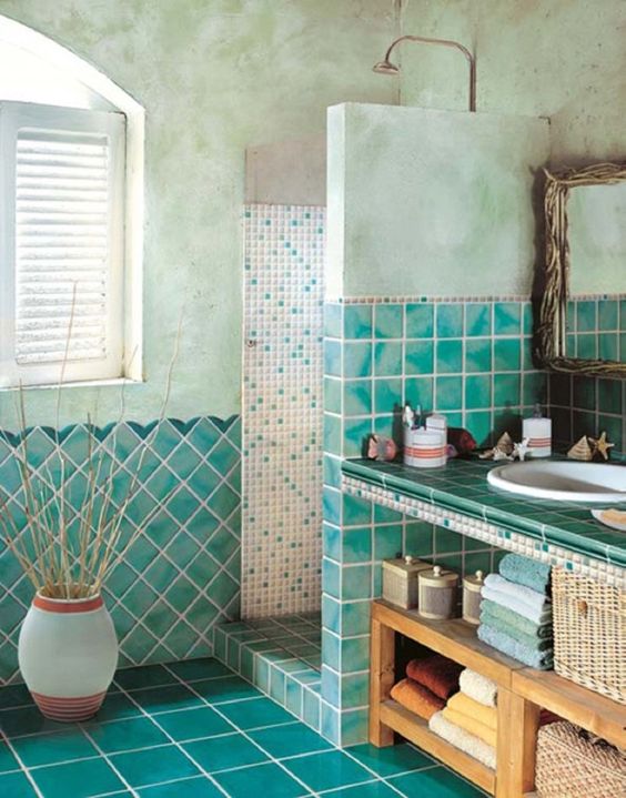 analogous bathroom with textural and watercolor turquoise tiles cover the walls and the shower and sleek glossy ones are covering the floor